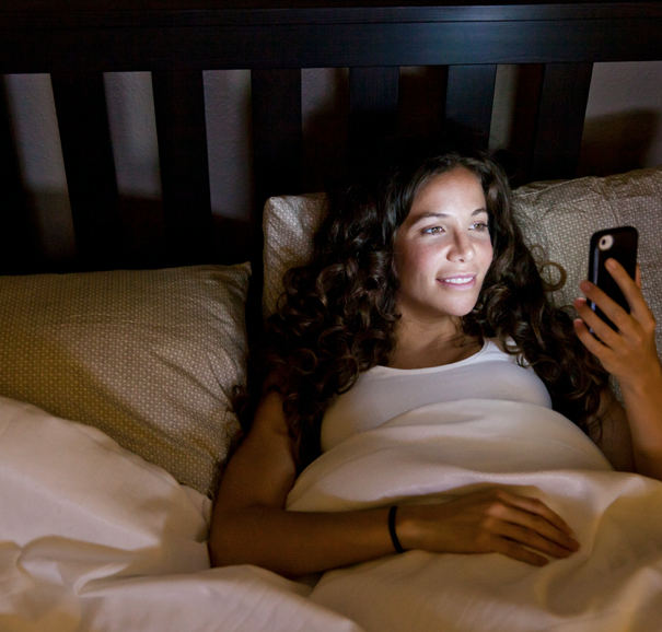 women on phone in bed 