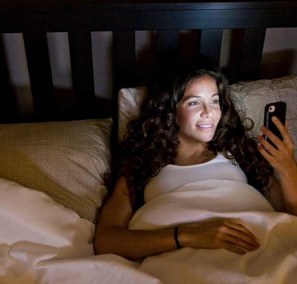 women on phone in bed