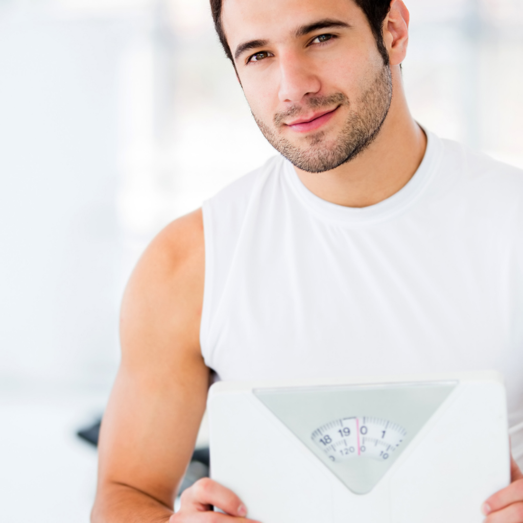 athletic man holding a weight scale