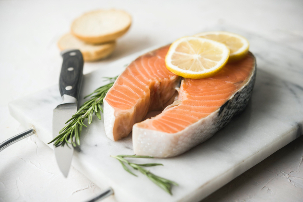 salmon on a cutting board with a knife