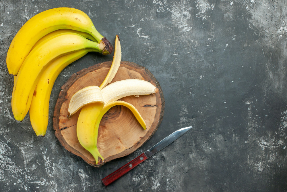 bananas on cutting board with cutting knife