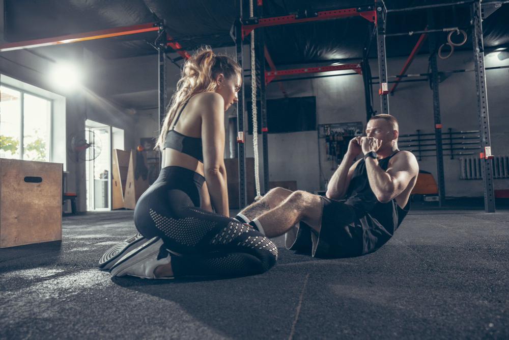 Beautiful young sporty couple workout in gym together.