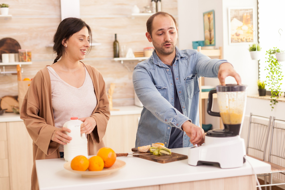 Couple mixing various fruits for nutritious and healthy smoothie. healthy carefree and cheerful lifestyle