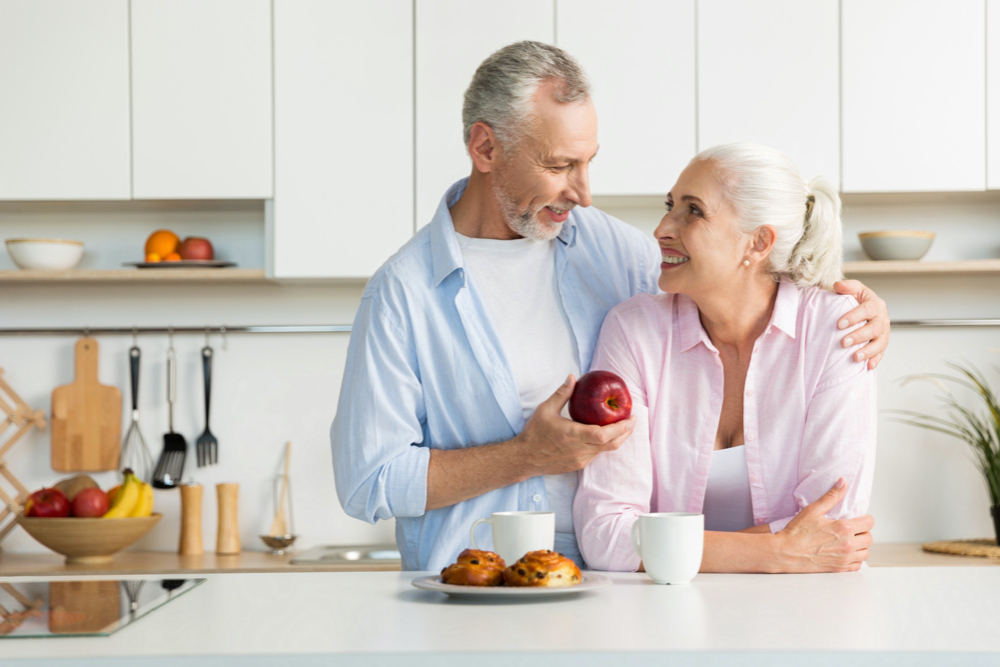 Smiling mature loving couple family standing at the kitchen