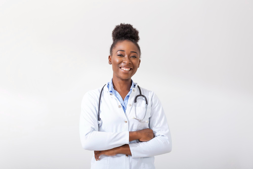 doctor with a stethoscope hand in her pocket closeup of a female smiling while standing straight on white background
