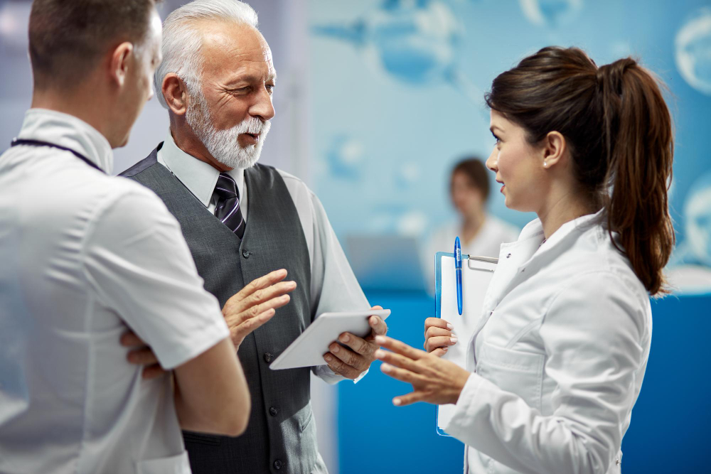 doctors communicating while standing in a lobby at medical facility