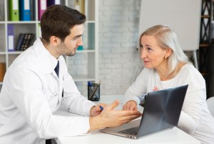 Doctor discussing lupus symptoms and treatment options with a patient during a medical consultation.